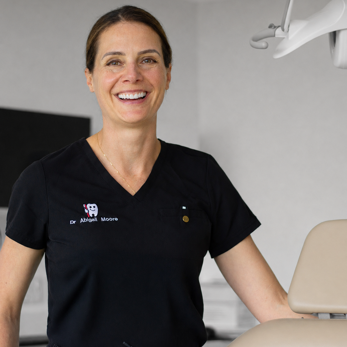 Dr Abbey smiling and posing in dental treatment room