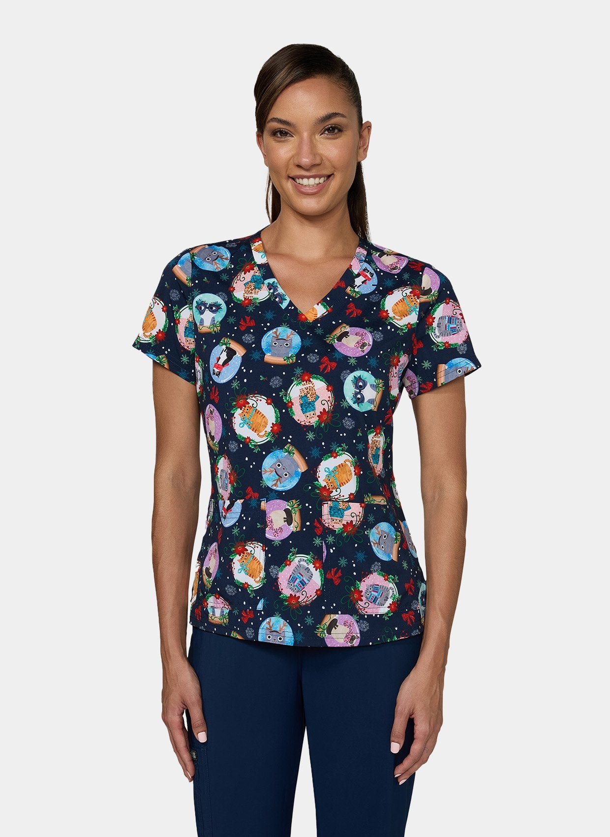 Woman wearing Koi Basics Leslie scrub top with colourful holiday cat print.